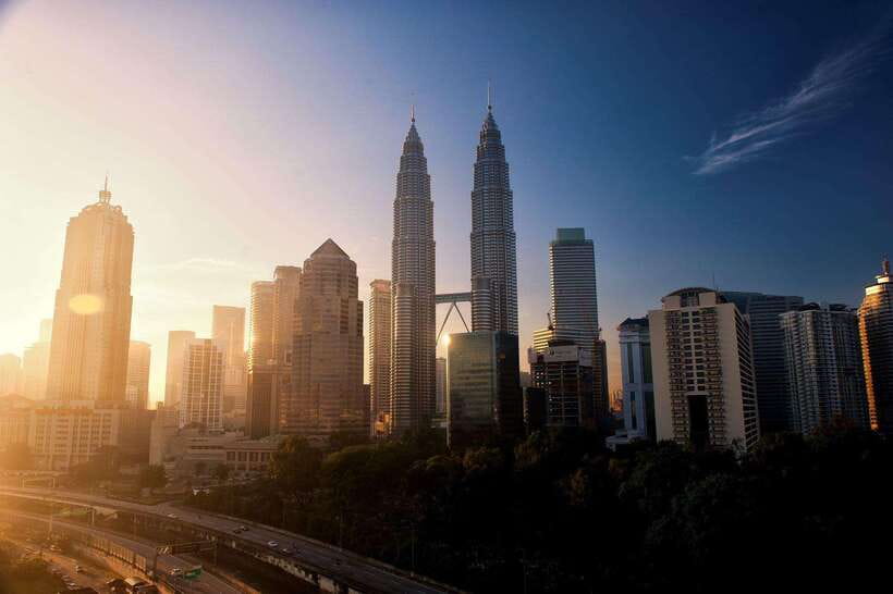The Kuala Lumpur skyline at dusk with the Petronas Twin Towers lit